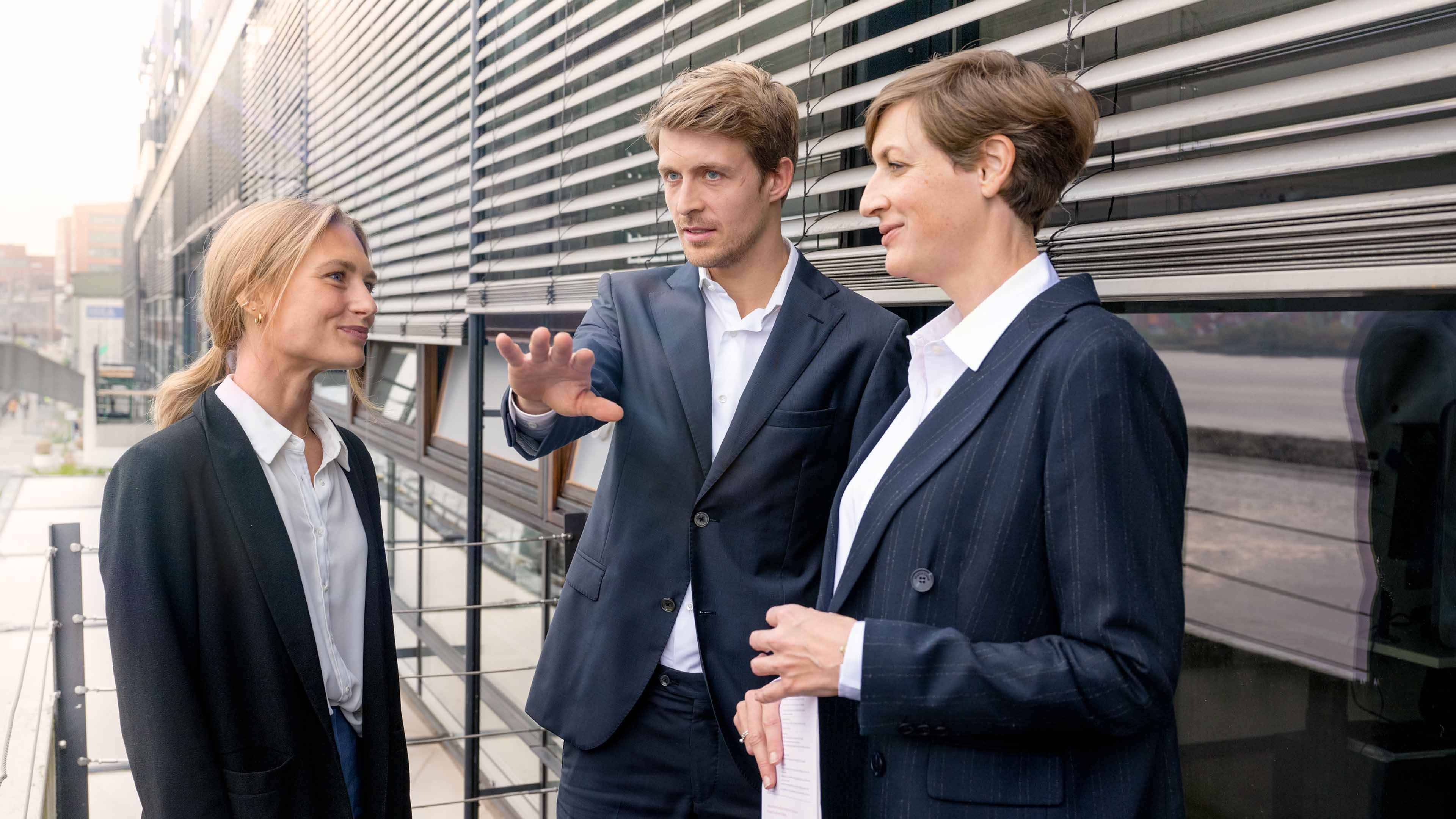 Menschen unterhalten sich vor einem Gebäude.