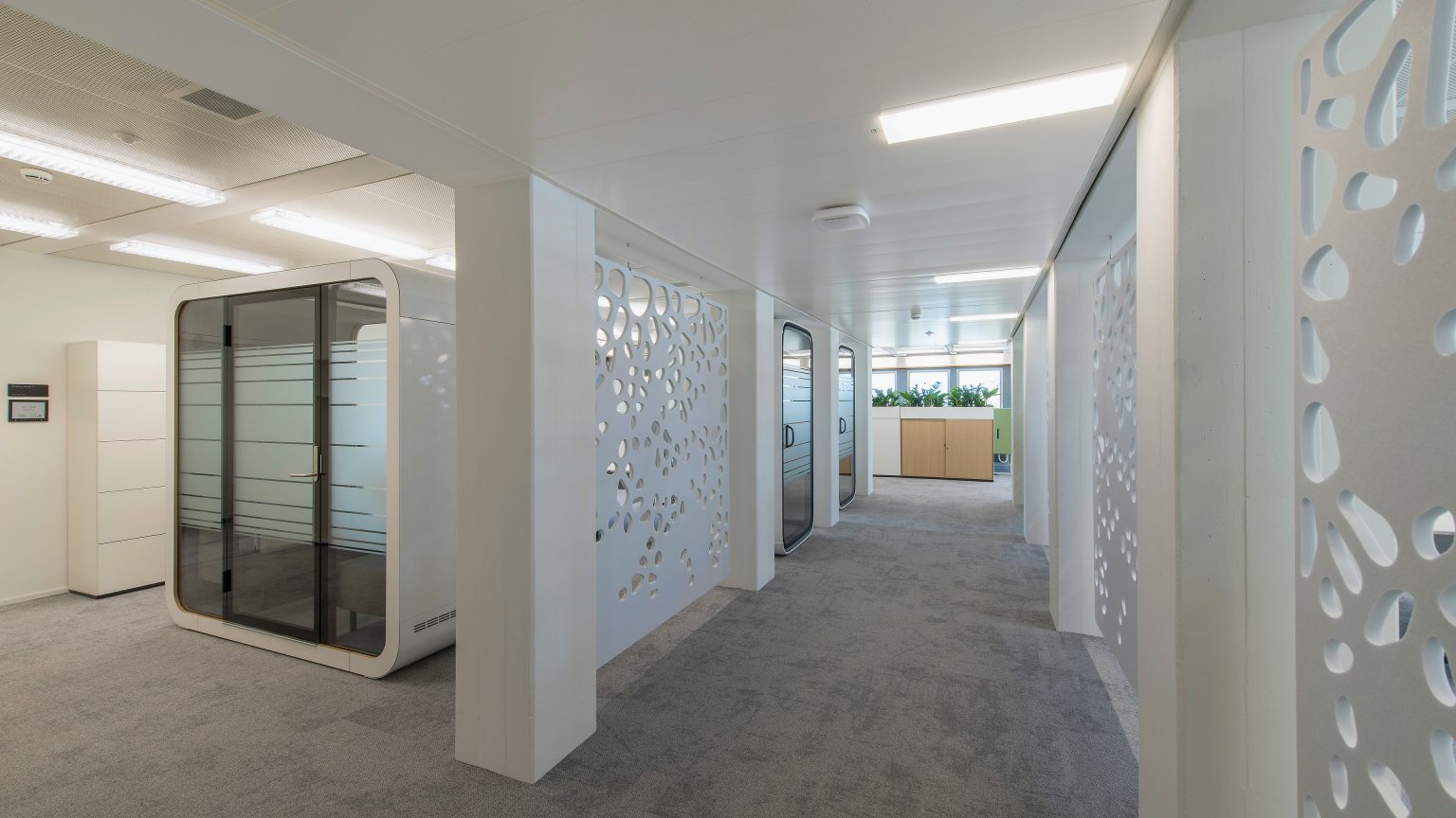 A corridor with acoustic screens and meeting booths.