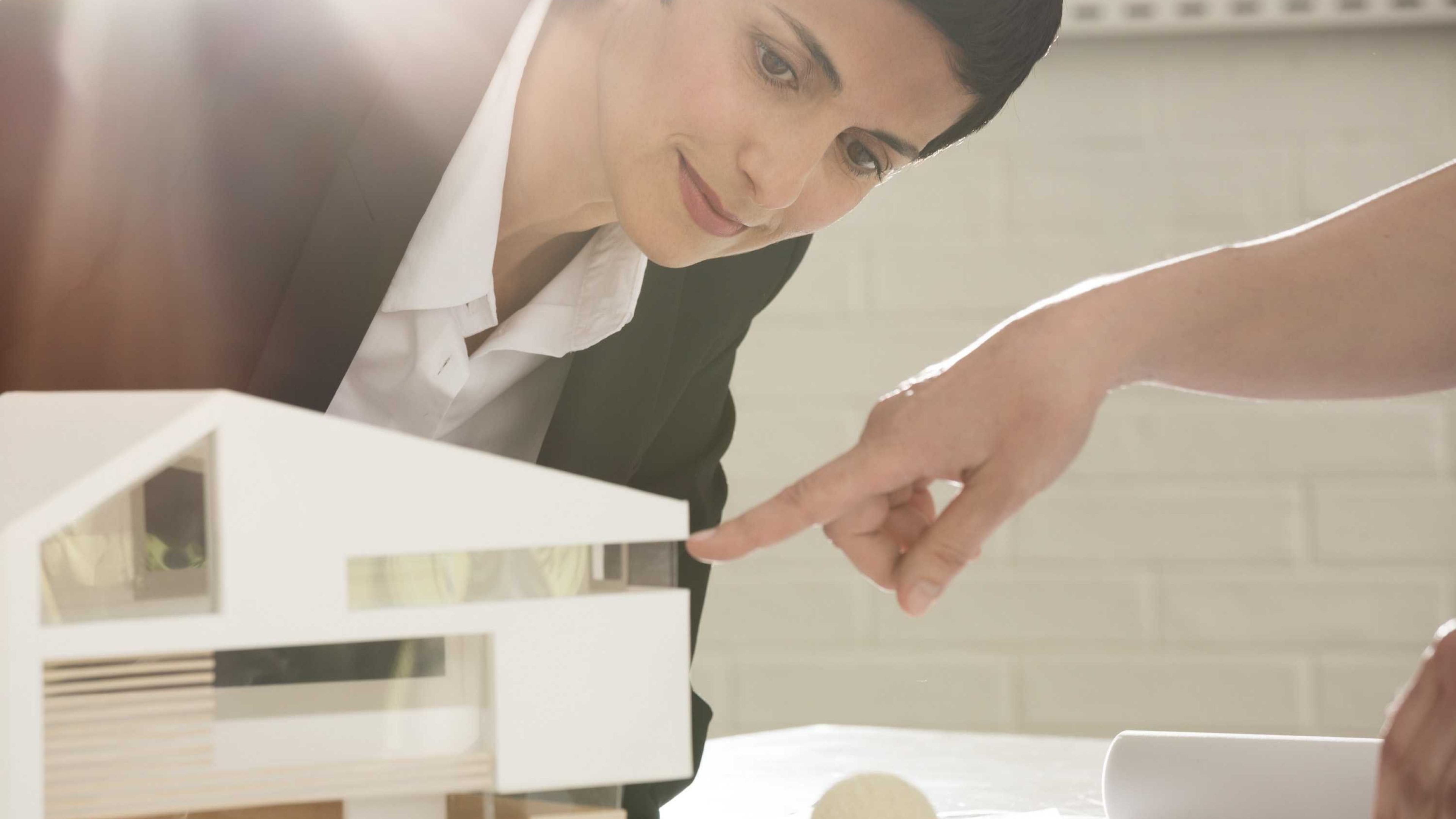 Exposé von Swiss Life Asset Managers: eine Frau die sich ein Modellhaus anschaut.