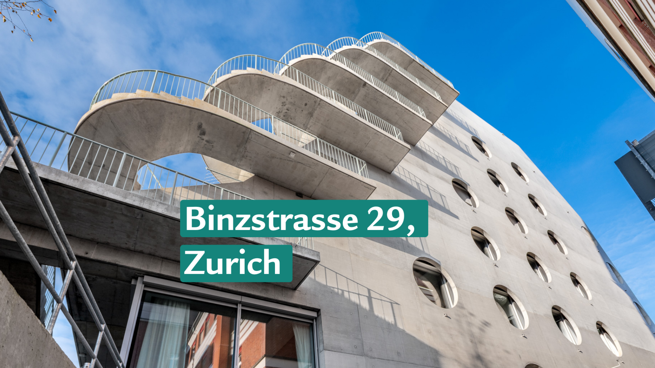 Batiment moderne en beton avec des balcons incurves et des fenetres rondes.