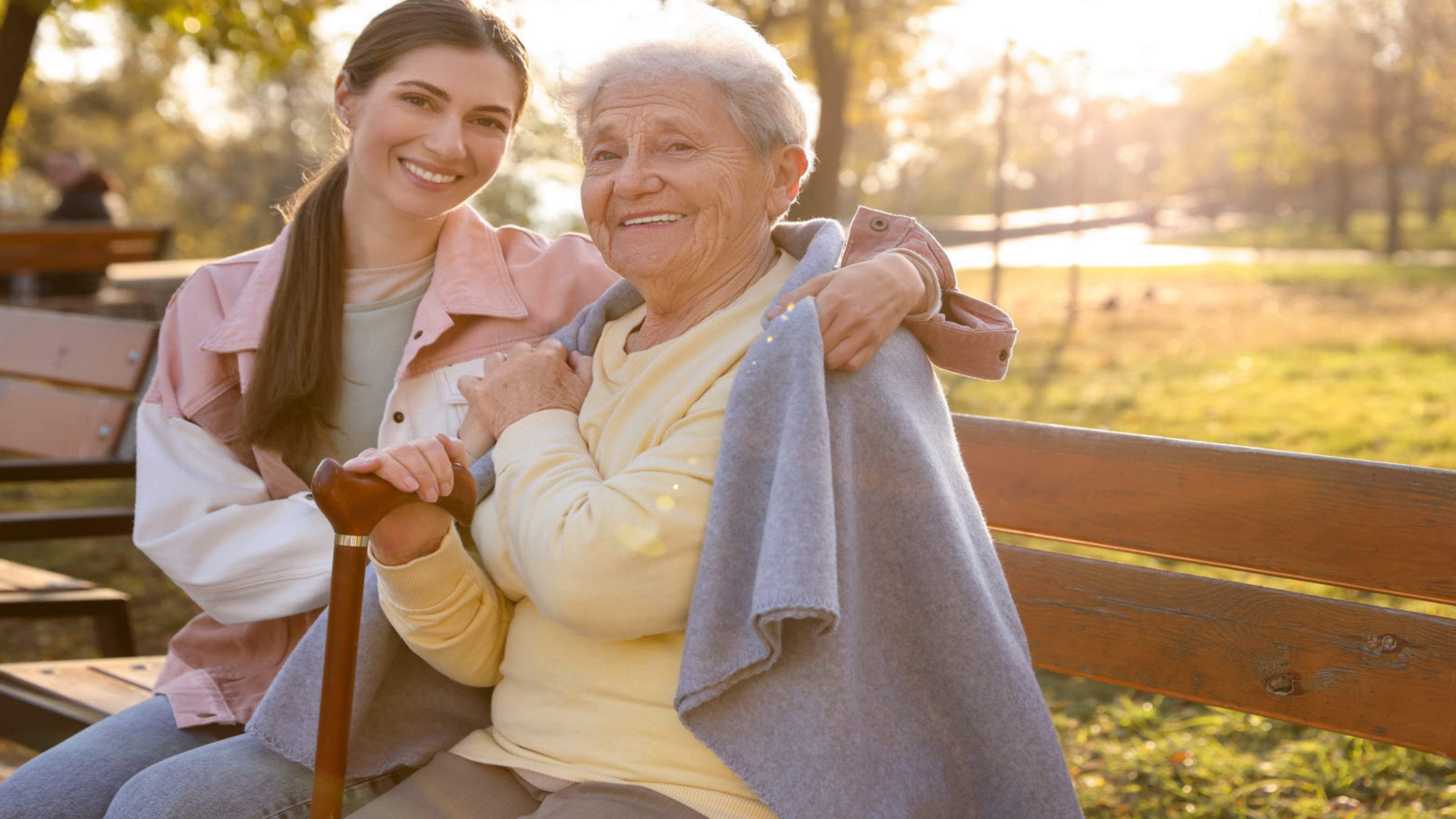 An older and a younger woman on a park bench.
